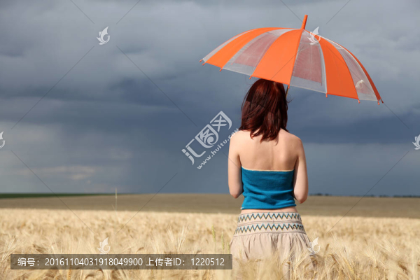 雨天在麥田里帶雨傘的女孩