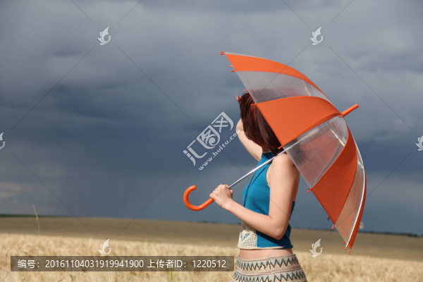 雨天在麥田里帶雨傘的女孩