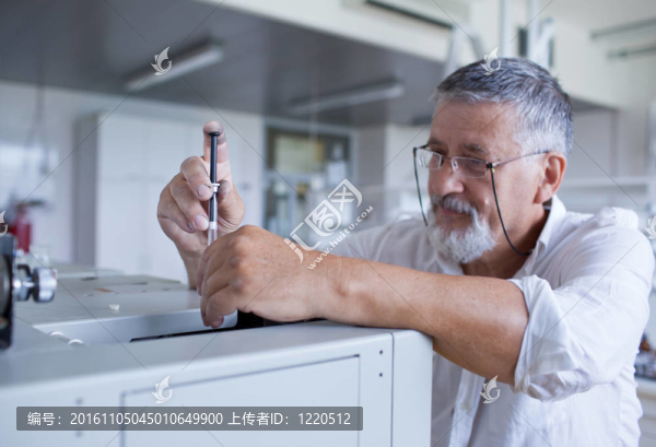 男性資深研究員開展科學(xué)研究，在實(shí)驗(yàn)室用氣相色譜儀（淺景深；顏色色調(diào)的圖像）