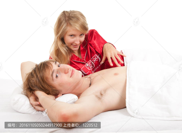 幸福的年輕夫婦在床上用品；白色背景