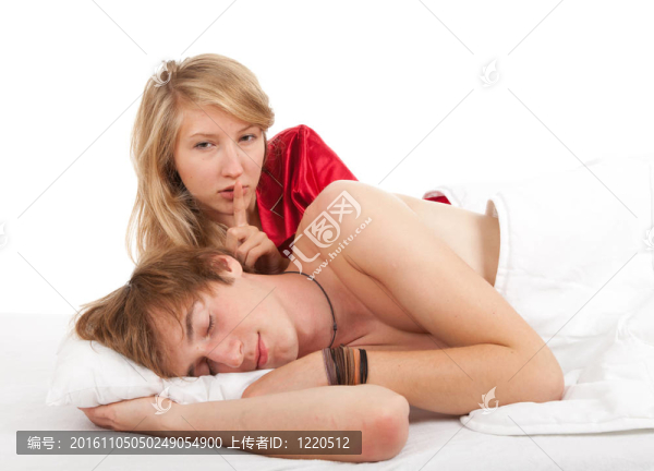 幸福的年輕夫婦在床上用品；白色背景