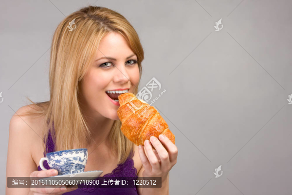 年輕的金發(fā)女人喝著早晨的咖啡