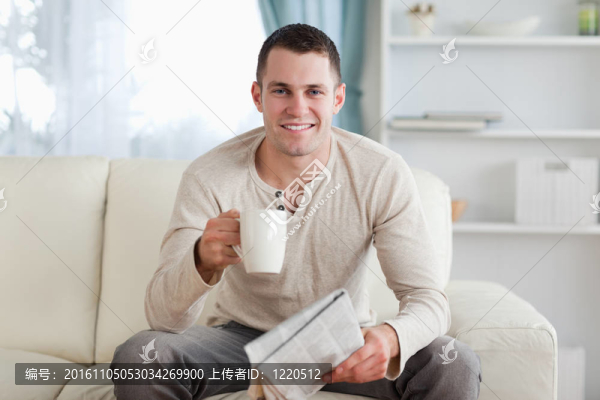 拿著報紙邊喝茶的男人