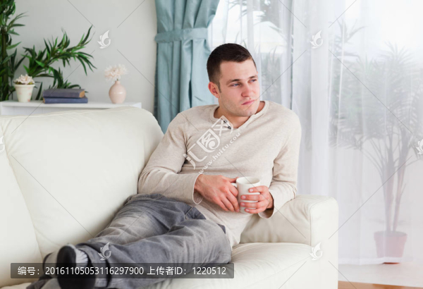 憂郁的男人拿著一杯咖啡