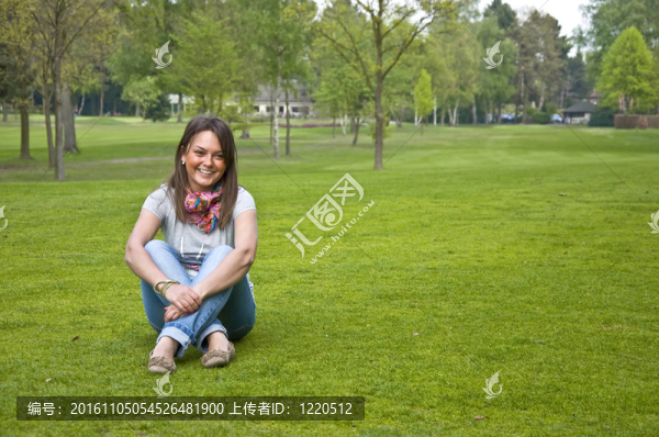 美麗迷人的女子坐在草地高爾夫球場。微笑.