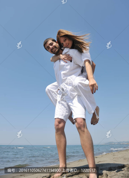 快樂的年輕夫婦在海灘上玩得很開心