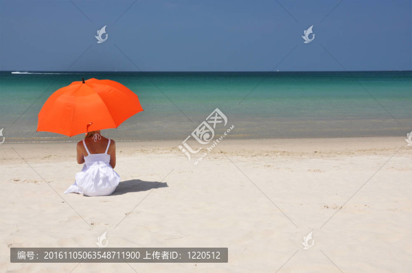 沙灘上帶著橙色雨傘的女孩