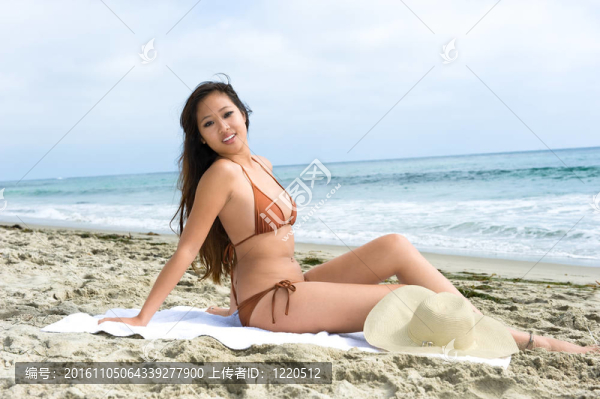 亞洲女性在海灘曬日光浴