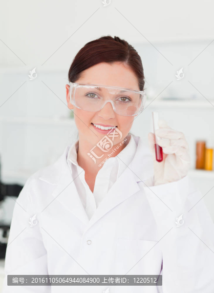 面帶微笑的科學(xué)家在實(shí)驗(yàn)室里拿著試管看著攝像機(jī)