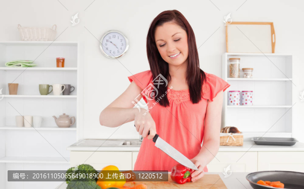 華麗的紅色頭發(fā)的女人在她的公寓廚房切一些蔬菜