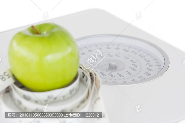 用卷尺和秤秤的綠色蘋果