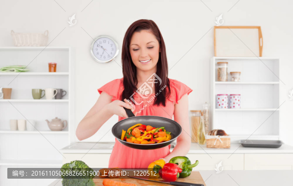 漂亮的紅發(fā)女人在廚房里做蔬菜