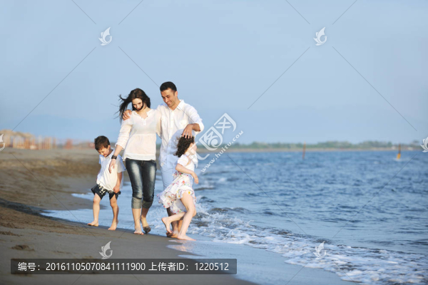 快樂的年輕家庭在海灘上享受日落