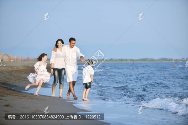 快樂的年輕家庭在海灘上享受日落
