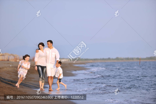 快樂的年輕家庭在海灘上享受日落