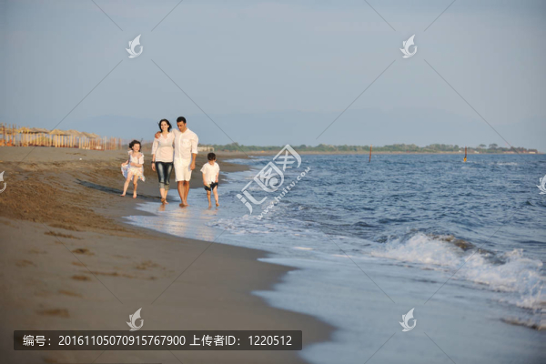 快樂的年輕家庭在海灘上享受日落