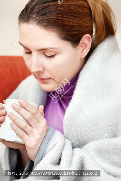 生病的女人手里拿著一杯茶
