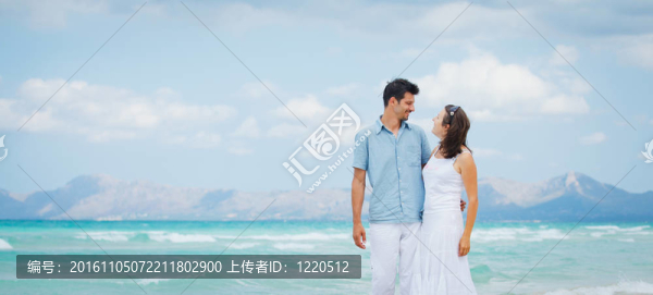 快樂的年輕夫婦在海灘上散步