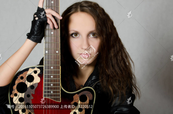 穿著皮夾克的漂亮女孩帶著吉他