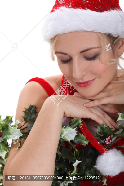 金發(fā)女子身穿圣誕服裝擁抱冬青和有純度的表達(dá)