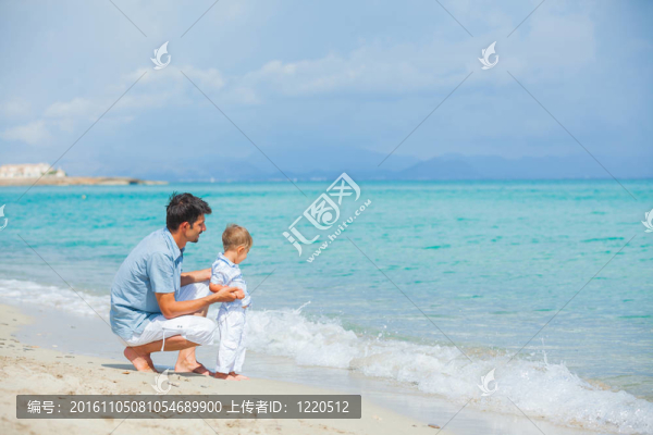 快樂的父親和他的兒子在海灘玩