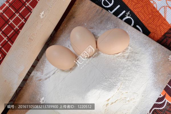 三個雞蛋在砧板與面粉