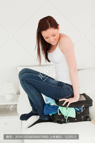 漂亮的女人坐在手提箱上