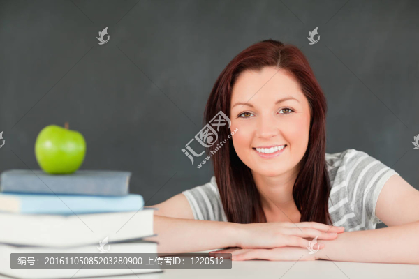 一個學生帶著書和一個蘋果