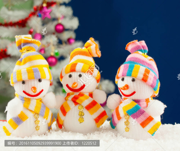 在藍(lán)色背景白色的裝飾常青樹前三個(gè)雪人