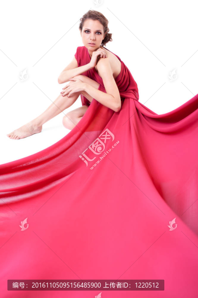 穿著紅色連衣裙的坐著的美麗的女人
