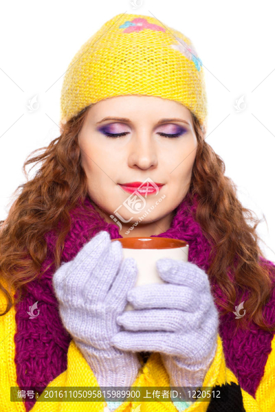 漂亮的女孩穿著冬天的衣服和杯子