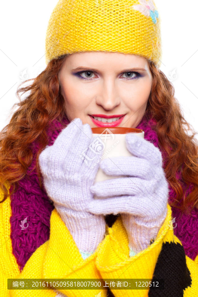 漂亮的女孩穿著冬天的衣服和杯子