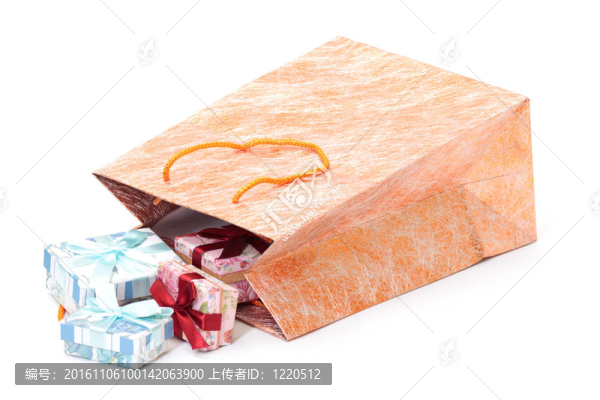 帶白色背景禮品的金色購物袋照片