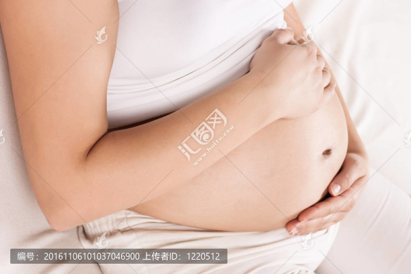懷孕的女人抱著她的肚子