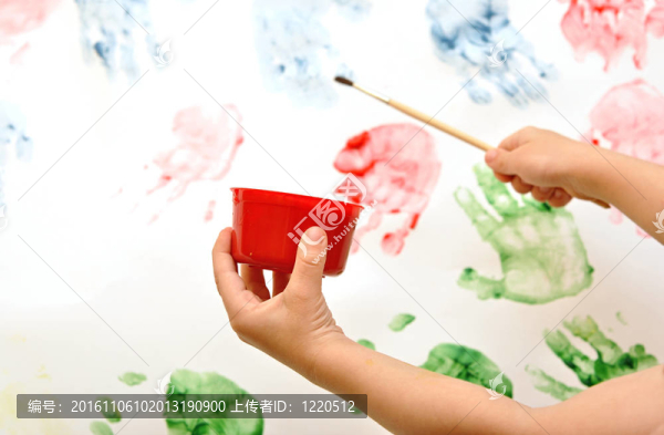 孩子的手刷水彩畫在畫架