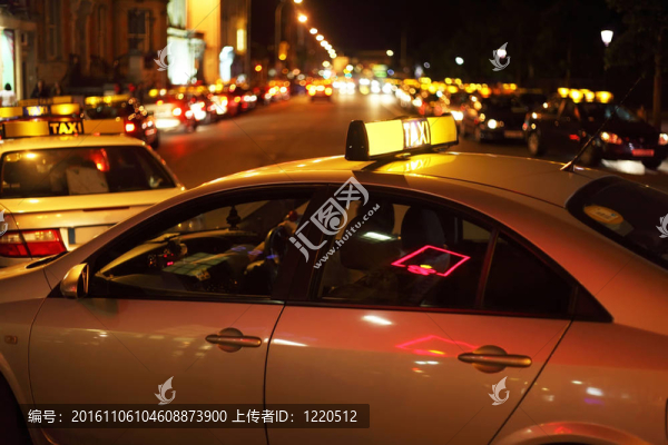 城市的夜生活。幾輛出租車在馬路上。許多明亮的燈光