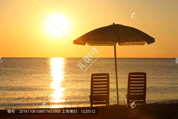 兩個空椅子站在海灘下打開傘與海洋日落的看法
