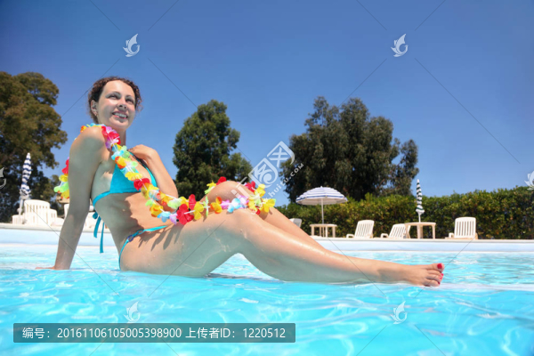 在白天的水池里，女人穿著藍(lán)色的游泳衣和顏色的項(xiàng)鏈；水下包裹