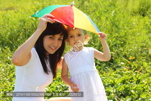 母親和女兒躲在太陽(yáng)傘下