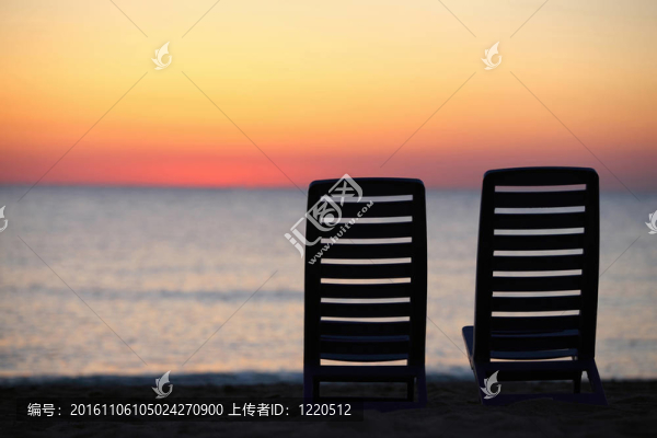 在傍晚時(shí)在海邊的兩塑料椅子成本晚上