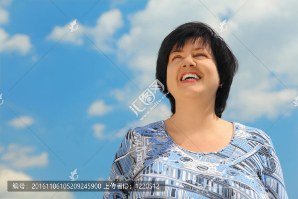 黑發(fā)豐滿成熟的女人微笑；藍色的天空和云彩