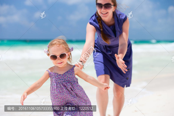 母親和女兒在海灘上跑步