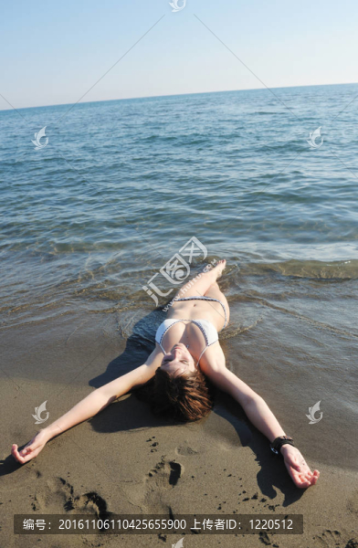 年輕的女人在海灘上放松