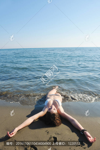 年輕的女人在海灘上放松