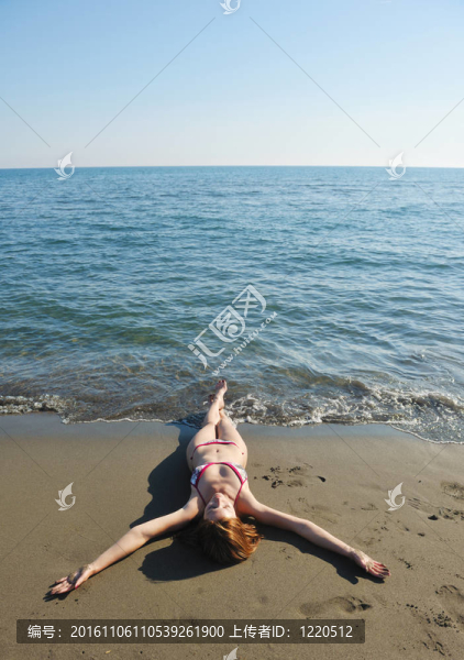 年輕的女人在海灘上放松