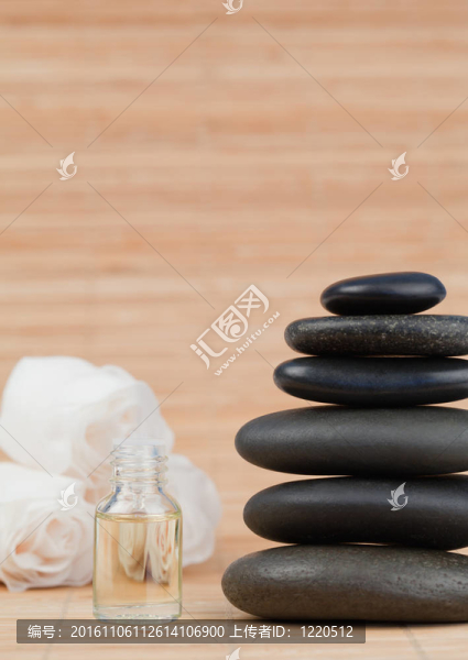 玫瑰玻璃瓶和一堆黑色的石子