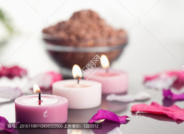 點燃的蠟燭與棕色的礫石碗和花瓣