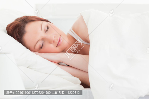 一個(gè)漂亮的紅發(fā)女人睡在她的床上