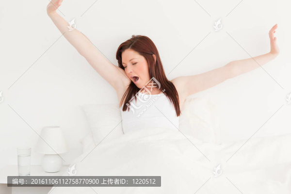 漂亮的紅發(fā)女性在床上伸展