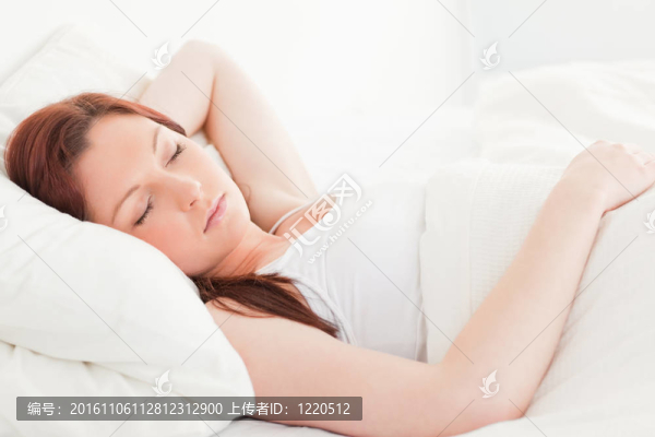 一個可愛的紅發(fā)女人睡在她的床上